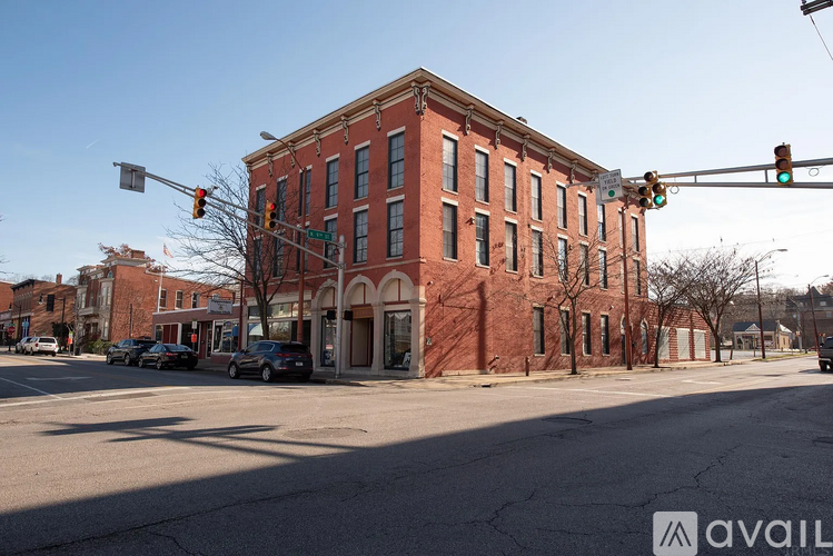 A red brick building is located on a street corner with a traffic light above it.