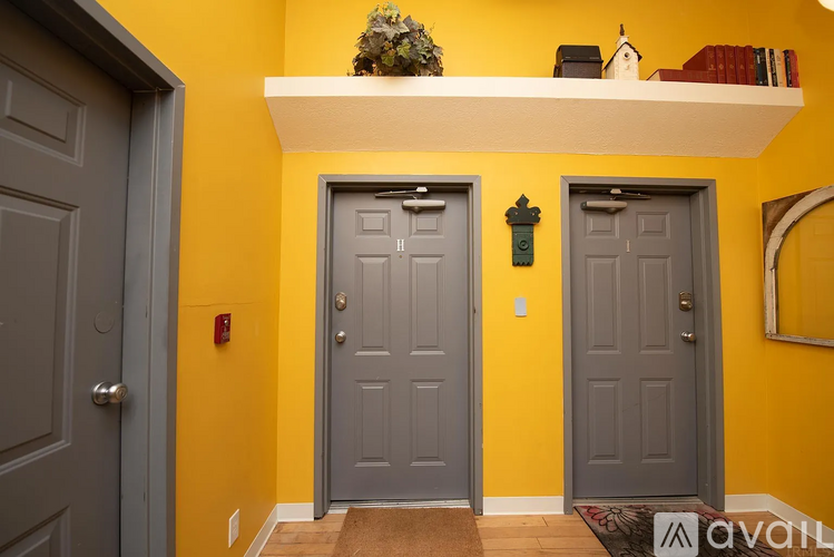A hallway with three doors and a shelf above them.