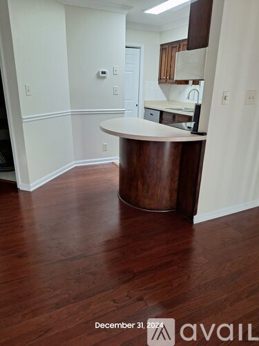 A wooden island in a kitchen with white walls and a white countertop.