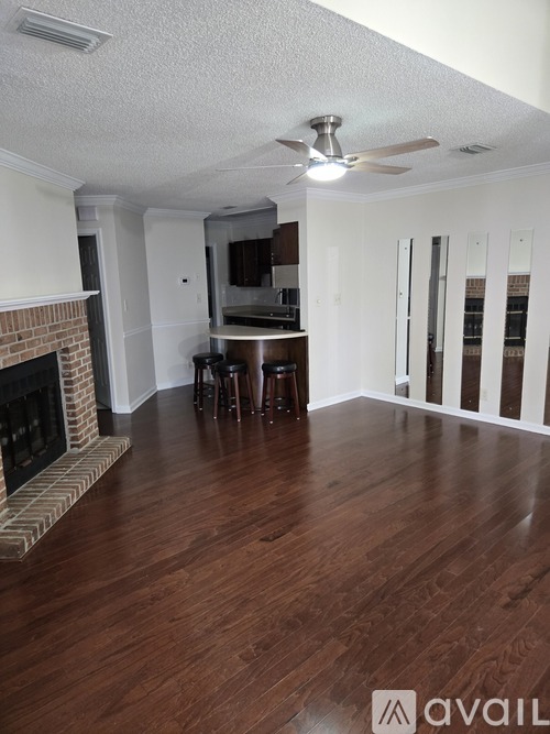 A living room with a fireplace and wooden floors.
