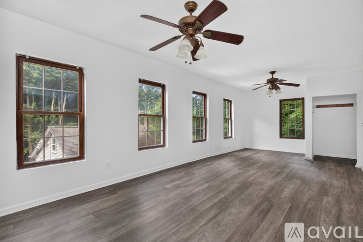 A room with a ceiling fan and wood flooring.