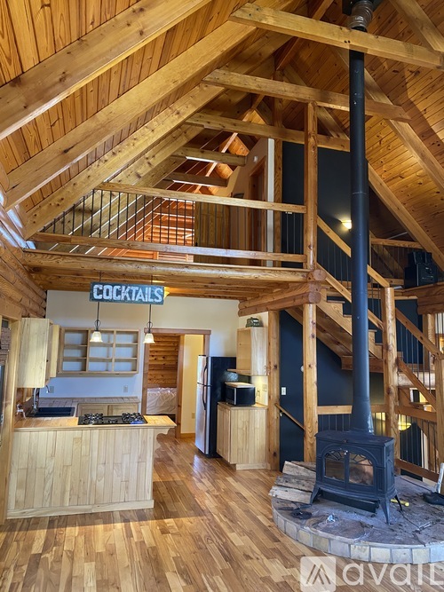 A wood-floored interior with a bar and a wood-burning stove.