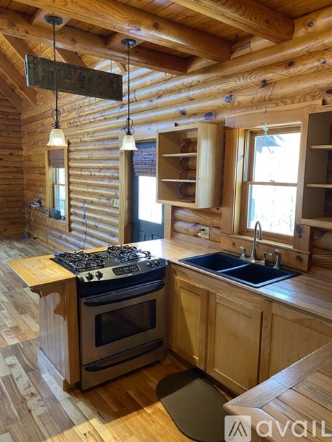 A kitchen with wooden cabinets and a stove top oven.