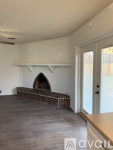 A room with a fireplace and wooden flooring.