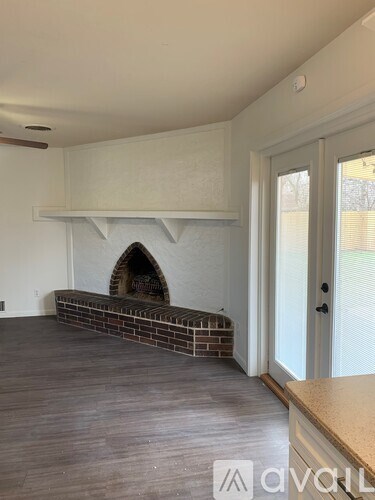 A room with a fireplace and wooden flooring.