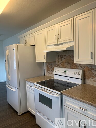 A kitchen with white appliances and cabinets.