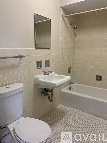 A white toilet sits next to a sink in a small bathroom.
