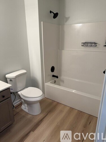 A white toilet sits next to a white bathtub in a bathroom.