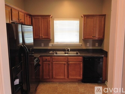 A kitchen with wooden cabinets and black appliances.