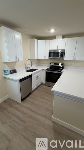 A kitchen with white cabinets and a black stove top oven.