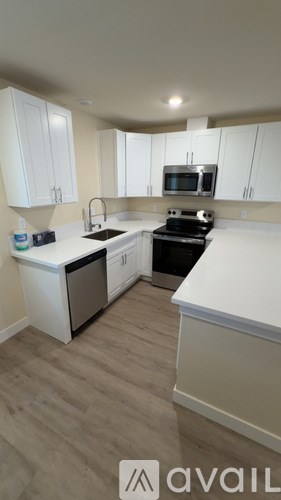 A kitchen with white cabinets and a black stove top oven.