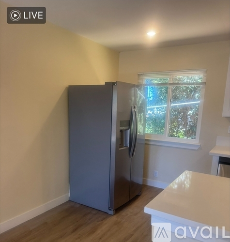 A stainless steel refrigerator is in a kitchen with a white countertop.