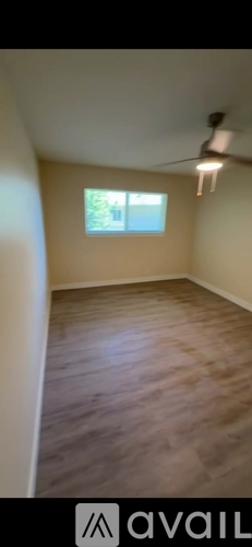 A room with wooden flooring and a window.