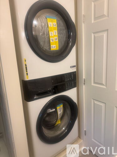 A white washing machine with a black control panel and a yellow sticker on the door.