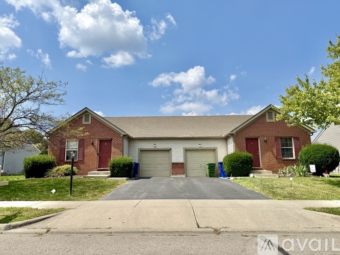A house with a red door and a garage is for sale.
