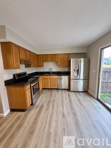A kitchen with wooden cabinets and a refrigerator.