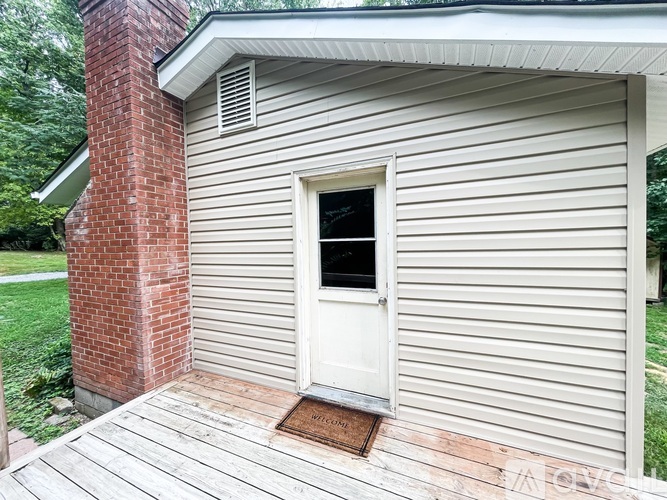 A small house with a white door and a brick chimney.