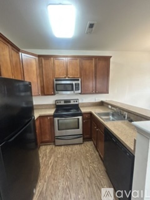 A kitchen with wooden cabinets and black appliances.