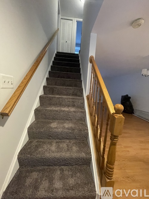 A staircase with a carpeted runner and wooden balusters.