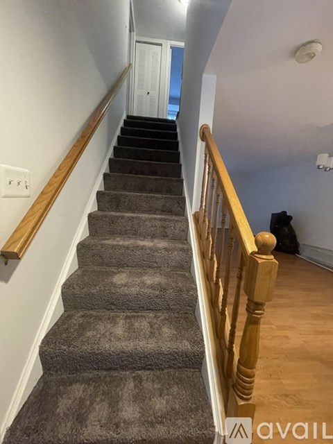A staircase with a carpeted runner and wooden balusters.
