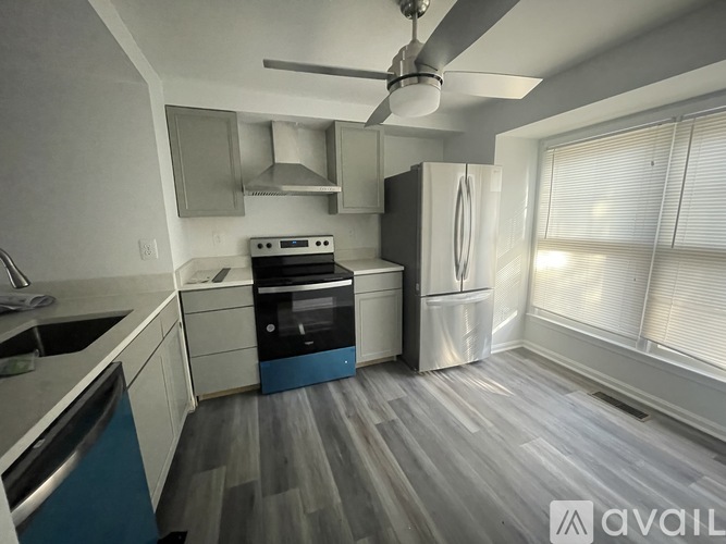 A modern kitchen with a blue dishwasher and a white refrigerator.