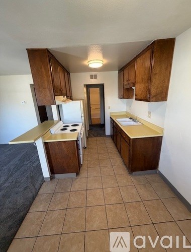 A kitchen with brown cabinets and a white fridge.