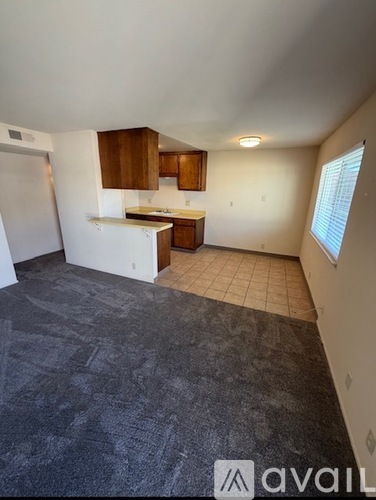 A kitchen with a refrigerator, sink, and cabinets.
