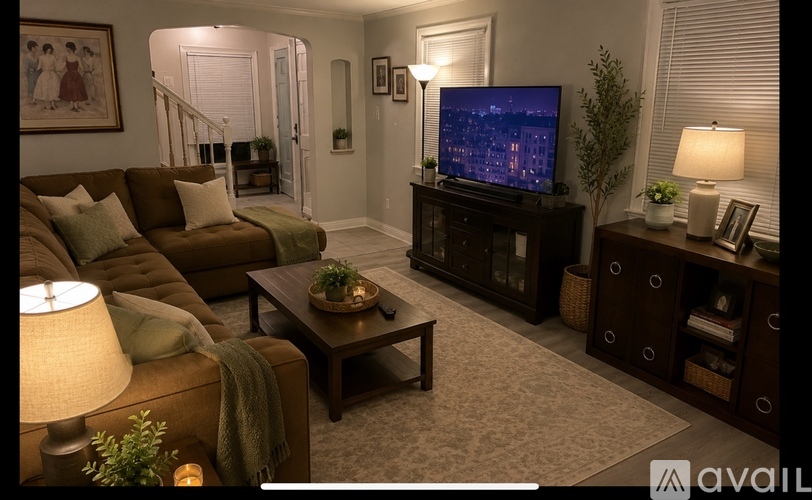 A living room with a couch, a coffee table, a television, and a lamp.