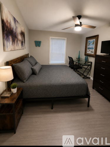 A bedroom with a bed, desk, and chair.