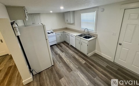 A kitchen with a white fridge, dishwasher, and sink.