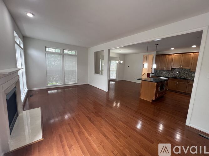 A spacious living room with hardwood floors and a fireplace.