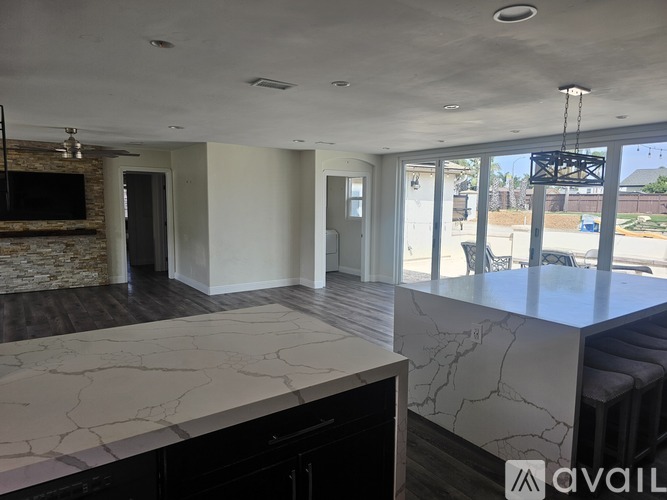 A spacious living room with a marble countertop and a stone fireplace.