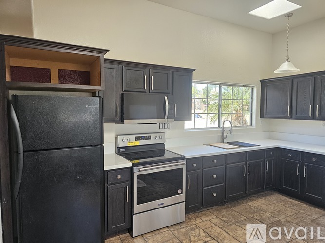 A kitchen with black cabinets and appliances is available for rent.