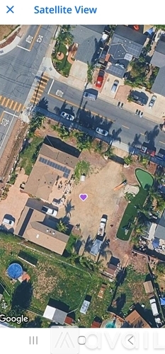 A satellite view of a residential area with houses and streets.