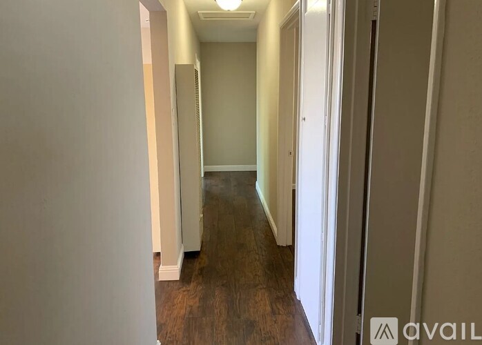 A long hallway with a light on the ceiling and a door on the right.