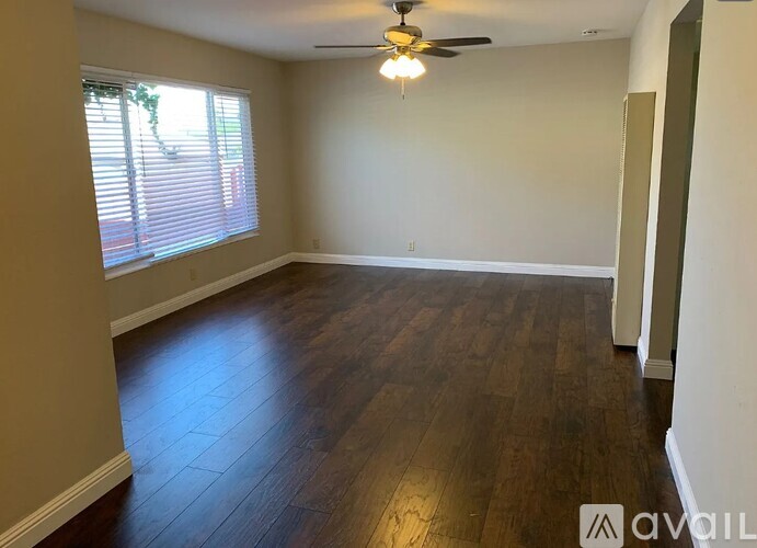 A room with wooden flooring and a ceiling fan.