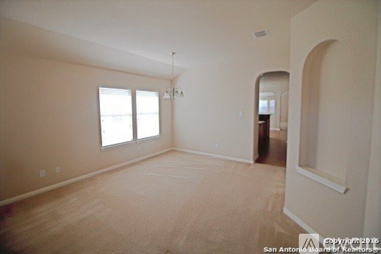 A spacious room with a carpeted floor and a window.