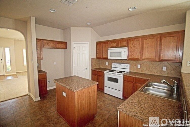 A kitchen with wooden cabinets and a white stove top oven.