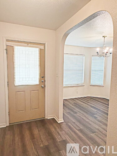 A room with a wooden floor and a door with a window above it.