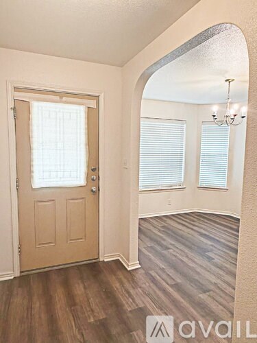A room with a wooden floor and a door with a window above it.