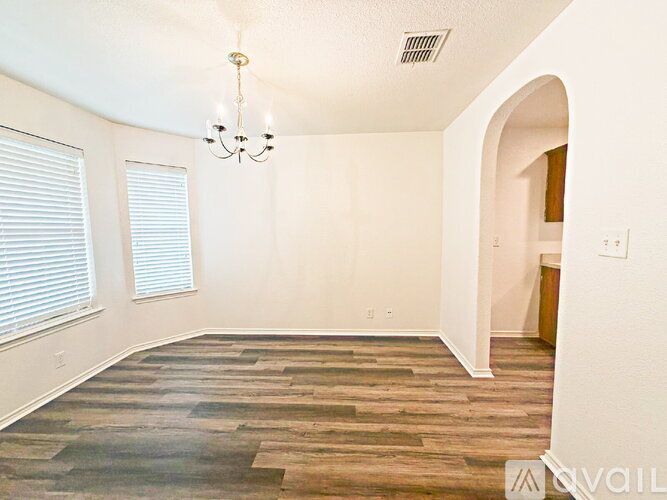 A room with a wooden floor and a chandelier.