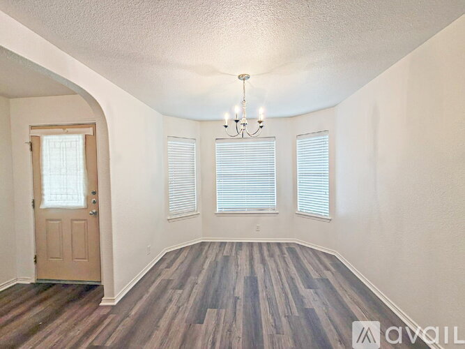 A room with wooden floors and a chandelier.