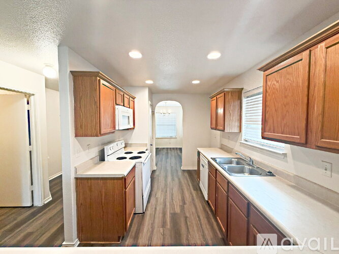 A kitchen with wooden cabinets and white appliances.
