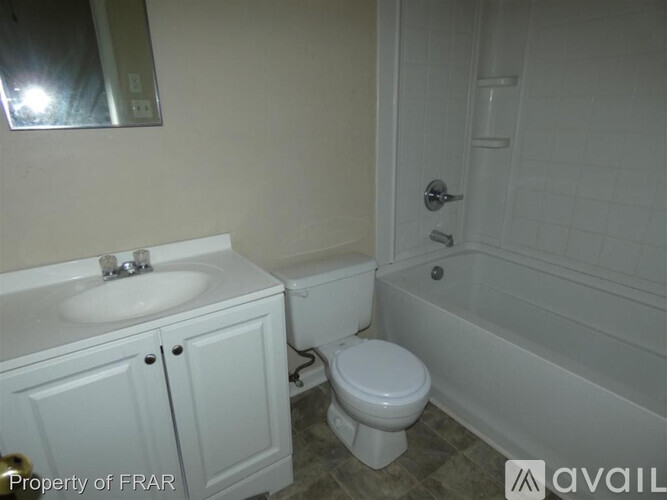 A white toilet sits next to a white sink in a bathroom.