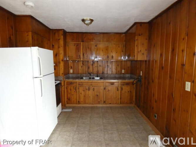 A kitchen with wooden cabinets and a white fridge.