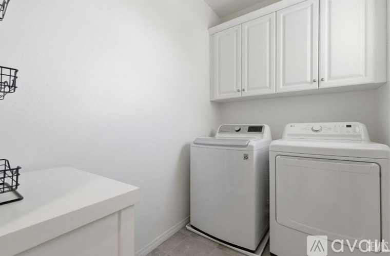 Two white front loading washing machines in a laundry room.
