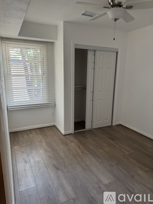 A room with a ceiling fan and a door.