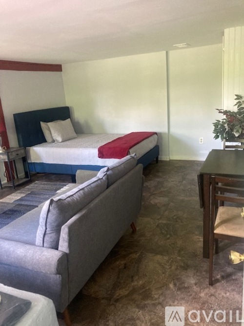 A bedroom with a bed and a couch.