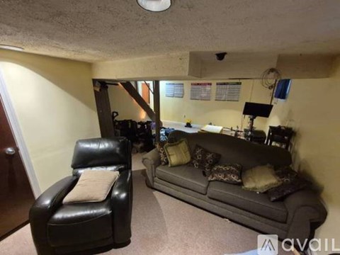 A living room with a couch, chair, and a television.