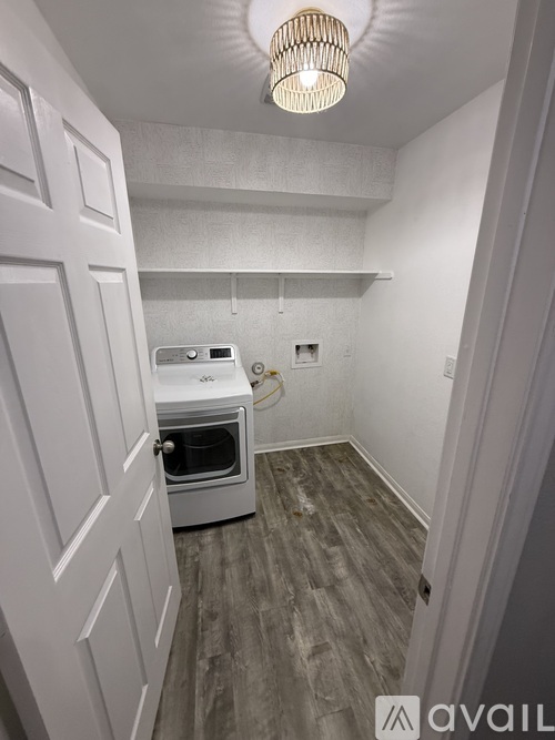 A kitchen with a white oven and wooden flooring.